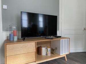 - une télévision à écran plat installée au-dessus d'un centre de divertissement en bois dans l'établissement Le 4B - Le Tiki, à Rouen