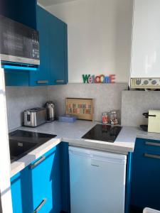 Una cocina con gabinetes azules y un fregadero. en Le 4B - Le Tiki, en Rouen 10 fotos más
