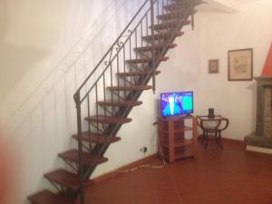 博爾戈阿莫札諾的住宿－Casa di Anchiano，带电视的客厅内的螺旋楼梯