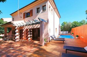 a house with a deck and a swimming pool at Tomymar in Cala Ratjada