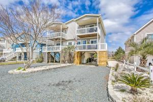 a large house with balconies and a driveway at Coastal Oasis with Decks Walk to Holden Beach! in Holden Beach