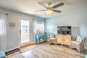 a living room with a ceiling fan and a tv at Coastal Oasis with Decks Walk to Holden Beach! in Holden Beach