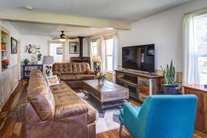 a living room with leather furniture and a flat screen tv at Charming Montrose Family Home Block to Downtown! in Montrose