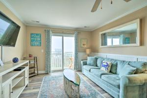 uma sala de estar com um sofá azul e uma janela em Ocean-View Oak Island Condo, 1 Block to Beach! em Oak Island