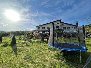 a playground in a field next to a house at Family hotel Borovitsa in Pŭdartsi