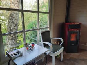 einen Tisch und einen Stuhl in einem Zimmer mit Fenster in der Unterkunft Scottish Wood Lodge in Ypern