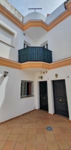 a room with two black doors and a balcony at Duplex Calle Padre Lerchundi con Parking y wifi in Chipiona