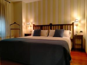 ein Schlafzimmer mit einem großen Bett und zwei eingeschalteten Lampen in der Unterkunft Hotel Palaterna in Pastrana + 10 Fotos
