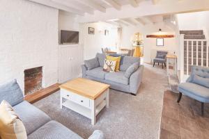 een woonkamer met 2 banken en een open haard bij Host & Stay - Dove Grey, 25 West End in Kirkbymoorside