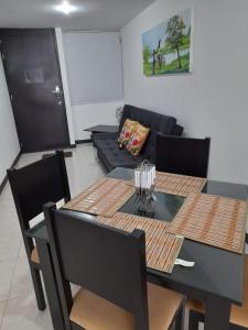 a living room with a table and a couch at Apartamentos y Piscina a 3 min del Parque Cafe in Montenegro +18 photos