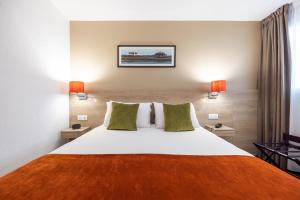 a bedroom with a large white bed with green pillows at Best Western Hotel Le Bordeaux Sud in Gradignan +32 photos