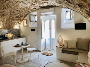 ein Wohnzimmer mit einem Sofa und einem Tisch in der Unterkunft Dimora Umberto - Dammuso Suite in Noto