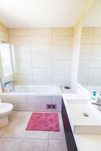 ein Badezimmer mit einer Badewanne, einem Waschbecken und einem WC in der Unterkunft Sun and Sea I in Caniço