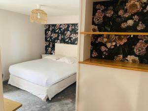 a bedroom with a bed and a painting of flowers at Hôtel Central in Avignon