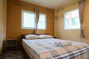 um quarto com uma cama e 2 janelas em Nat Resort Koh Tao em Ko Tao