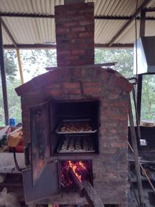 錫爾瓦尼亞的住宿－Hospedaje Rural El Rancho de Amelia y Juancho，砖炉里面放着食物