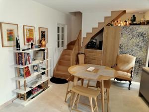 ein Esszimmer mit einem Tisch und einer Treppe in der Unterkunft 12 Rue des Ecoles in Saint-Émilion