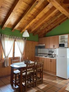 a kitchen with a table and a white refrigerator at El Hayuco de Montejo in Montejo de la Sierra