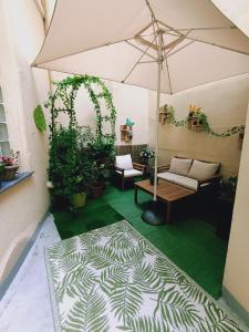 ニースにあるNice appartement cosy + patio privéのパティオ(傘、植物、ソファ付)