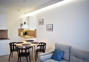 uma sala de estar com uma mesa e cadeiras e um sofá em Apartos Apartamenty Grano Residence em Gdansk