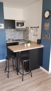 a kitchen with a wooden table and two stools at JOLI STUDIO 50M DE LA MER in Valras-Plage +14 photos