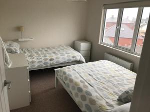 a bedroom with two beds and a window at West Strand View in Portrush