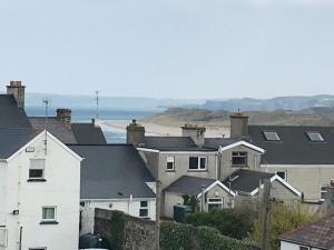a group of houses with a beach in the background at West Strand View in Portrush