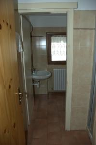 Elle comprend une petite salle de bains pourvue d'un lavabo et d'une fenêtre. dans l'établissement Casa Vacanze Ca' De Val, à Campodolcino