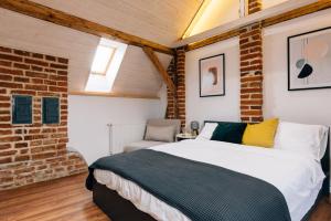 a bedroom with a bed and a brick wall at Principia Apartments in Turda