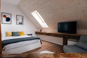 a bedroom with a bed and a flat screen tv at Principia Apartments in Turda