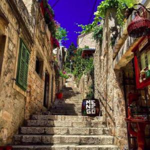 a stone alley with a me exit sign on the stairs at Apartment Bibić - Hvar center old town in Hvar