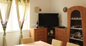 a living room with a flat screen tv and a table at Apartmani Marko in Lun