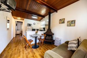een woonkamer met een bank en een open haard bij Ap Casal Localização e Segurança in Campos do Jordão