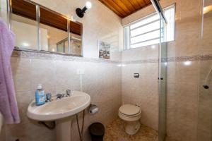 een badkamer met een wastafel, een toilet en een douche bij Ap Casal Localização e Segurança in Campos do Jordão +15 foto's