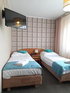 een hotelkamer met 2 bedden en een flatscreen-tv bij RB Rooms&Apartments in Bydgoszcz