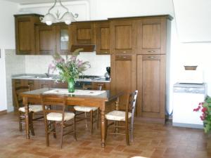 a kitchen with a wooden table with chairs and a table at Casa Vacanze Miravalle in Minucciano