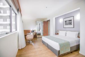 a hotel room with a bed and a desk at Iate Hotel Centro Florianópolis by RB Hotelaria in Florianópolis