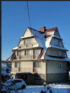 a house that has a snow covered roof at Janiołowo Ostoja in Bukowina Tatrzańska