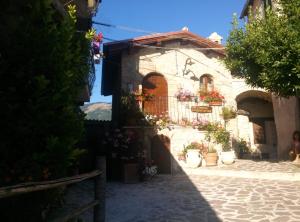 a building with potted plants on the side of it at B&B La Casetta sul Lago in Colle di Tora