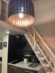 dużą lampkę wiszącą nad kuchnią ze zlewem w obiekcie "Mini apartamentai", Malūno Vilos w Połądze