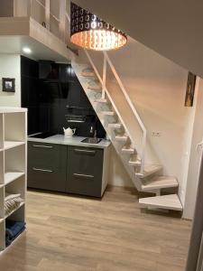 schody w kuchni ze zlewem i lampką w obiekcie "Mini apartamentai", Malūno Vilos w Połądze