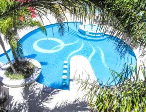 an overhead view of a swimming pool with palm trees at Quorum Córdoba Hotel, Resort Urbano in Córdoba
