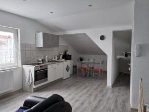 una cucina con elettrodomestici bianchi e tavolo con sedie di Apartment 2020 a Kirchhain