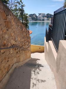 una pared de piedra junto a un cuerpo de agua en Joli studio les pieds dans l eau avec place de Parking gratuite en Bandol