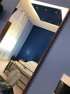 ein Spiegel, der ein Schlafzimmer mit einem Bett und einem Fenster reflektiert in der Unterkunft Hotel Degli Amici in Sant'Egidio del Monte Albino
