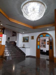 a lobby with a chandelier and stairs in a building at Hotel De Rosa in Boscoreale