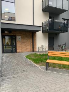 a wooden bench sitting in front of a building at Apartament Fordon przy Onkologii in Bydgoszcz