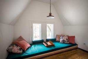 ein blaues Sofa in einem Zimmer mit Fenster in der Unterkunft 2stāvu PARKA NAMIŅŠ Viesturdārzā pērļu medniekiem! in Riga