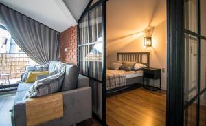 een slaapkamer met een bank en een bed in een kamer bij Apartamenty W37 in Nowy Targ