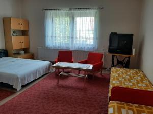 a bedroom with two beds and a table and two chairs at Farkas Piroska Vendégház in Bogács